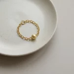 Luz Sutil – Anillo dorado con cadena y esfera minimalista - Imagen 2